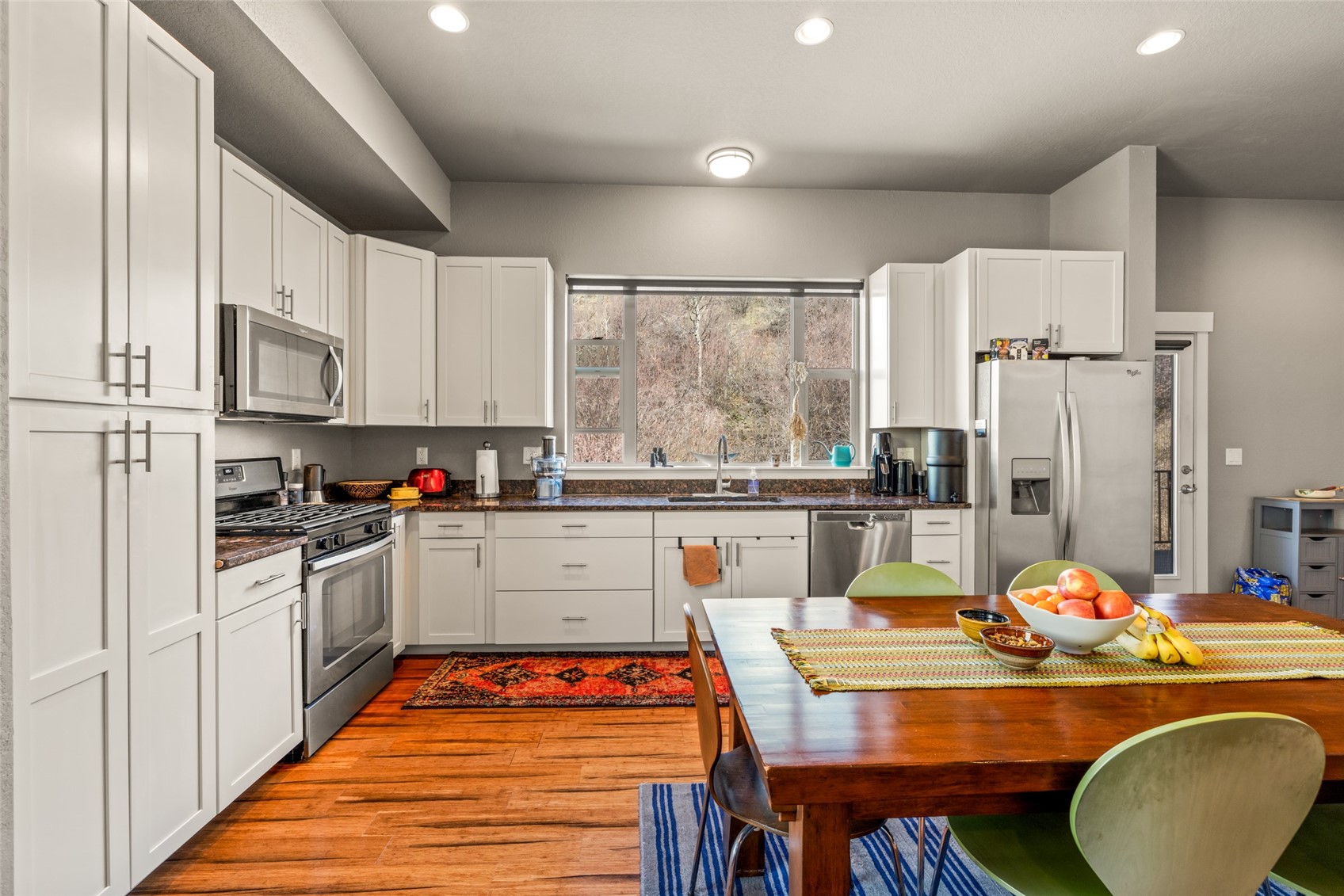 1680 Copper Ridge Drive, Unit 101 Steamboat Springs, CO 80487 - Photo 13 of 21 a kitchen with stainless steel appliances granite countertop a stove a sink dishwasher and white cabinets with wooden floor