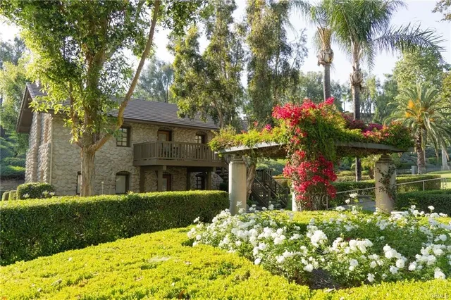 a front view of a house with a yard and fountain