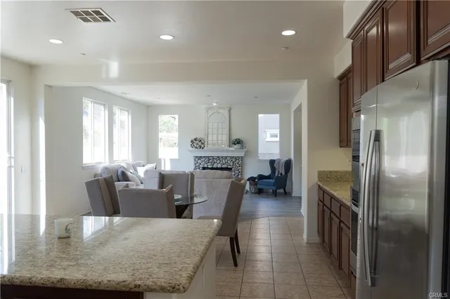 a large living room with stainless steel appliances furniture a chandelier