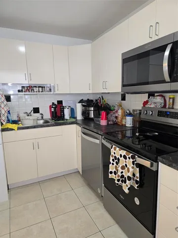 a kitchen with appliances a sink and cabinets