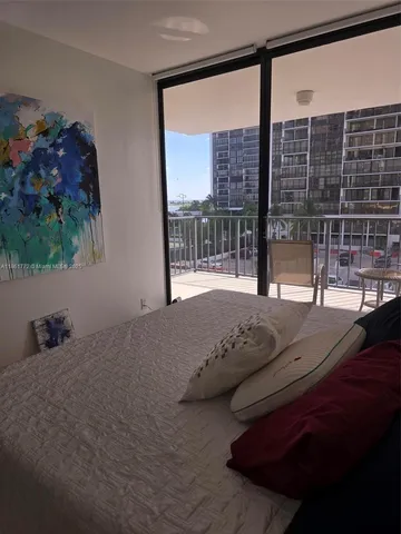 a bedroom with a bed and a large window with outer view