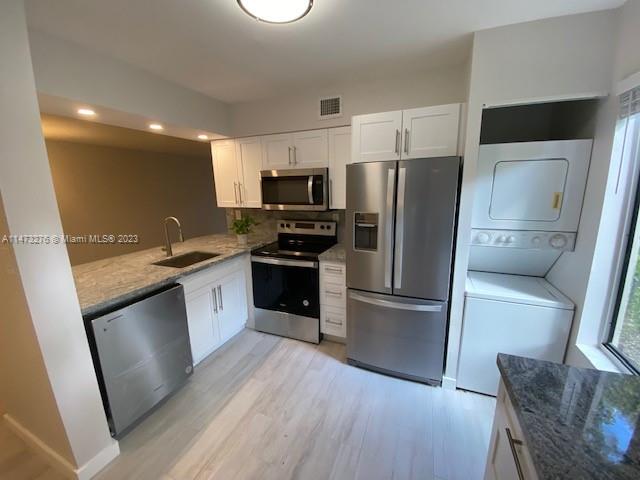 9071 Southwest 141st Place, Unit 9071 Miami, FL 33186 - Photo 4 of 10 a kitchen with a refrigerator sink and wooden floor