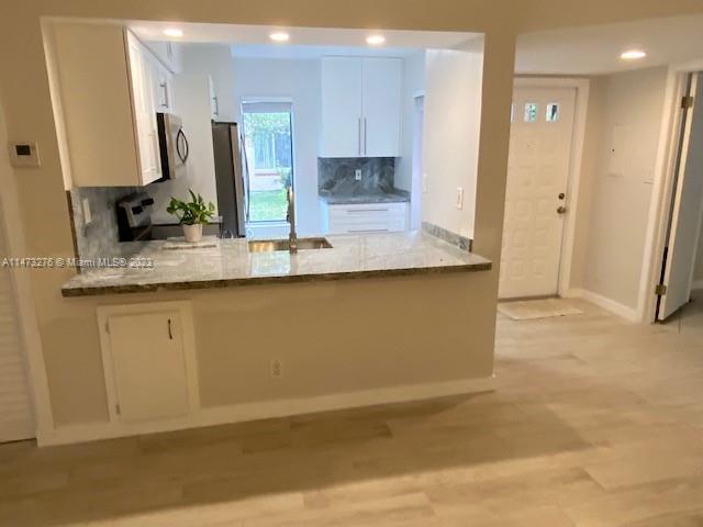 9071 Southwest 141st Place, Unit 9071 Miami, FL 33186 - Photo 5 of 10 a kitchen with stainless steel appliances granite countertop a sink a stove and a refrigerator