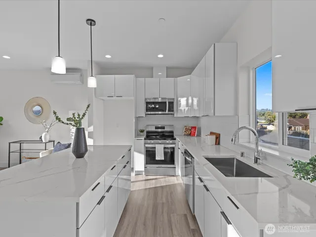 a kitchen with kitchen island a counter top space a sink stainless steel appliances and cabinets