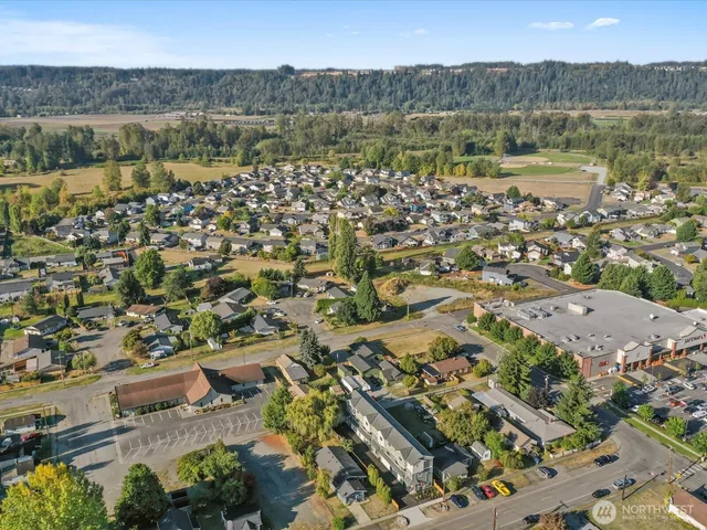 an aerial view of residential house with parking and trees