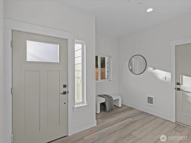 a view of a room with wooden floor mirror and windows