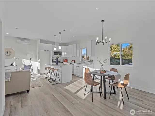 a view of a dining room and livingroom with furniture wooden floor a chandelier