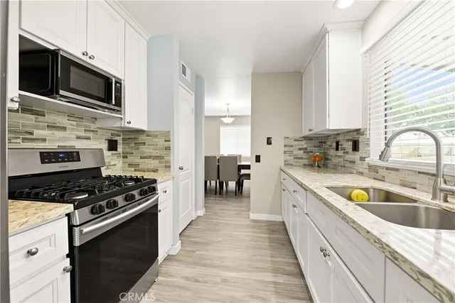 a kitchen with stainless steel appliances a stove sink microwave and cabinets