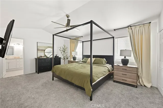 a bedroom with a bed a mirror on dresser and a chandelier