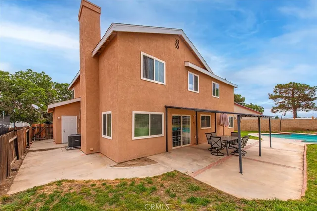 a view of a house with backyard and sitting area