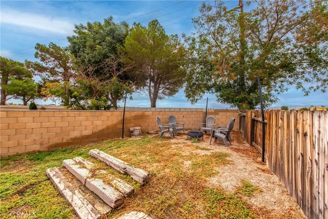 a view of a backyard with wooden fence and a bench