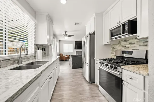 a kitchen with stainless steel appliances a stove sink microwave and cabinets