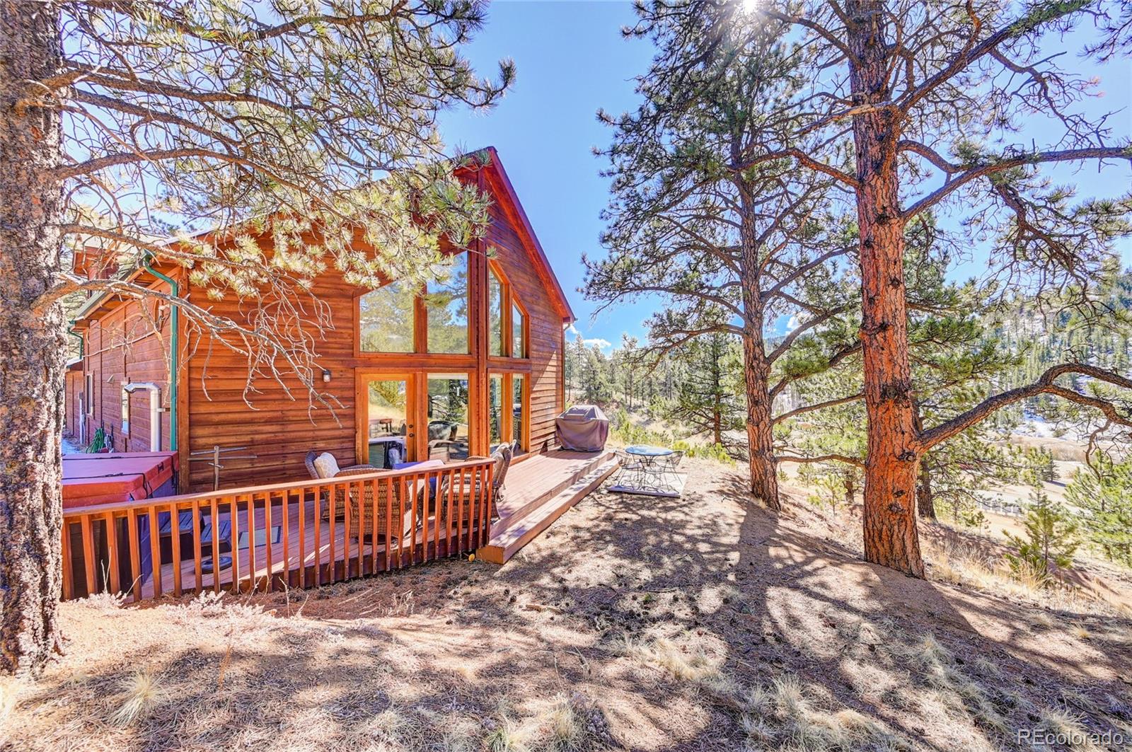 311 North Random Road Bailey, CO 80421 - Photo 4 of 40 a view of a house with a wooden fence and trees