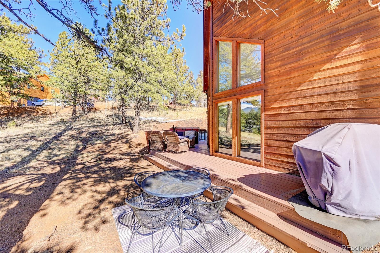 311 North Random Road Bailey, CO 80421 - Photo 6 of 40 a view of a patio with table and chairs and wooden floor