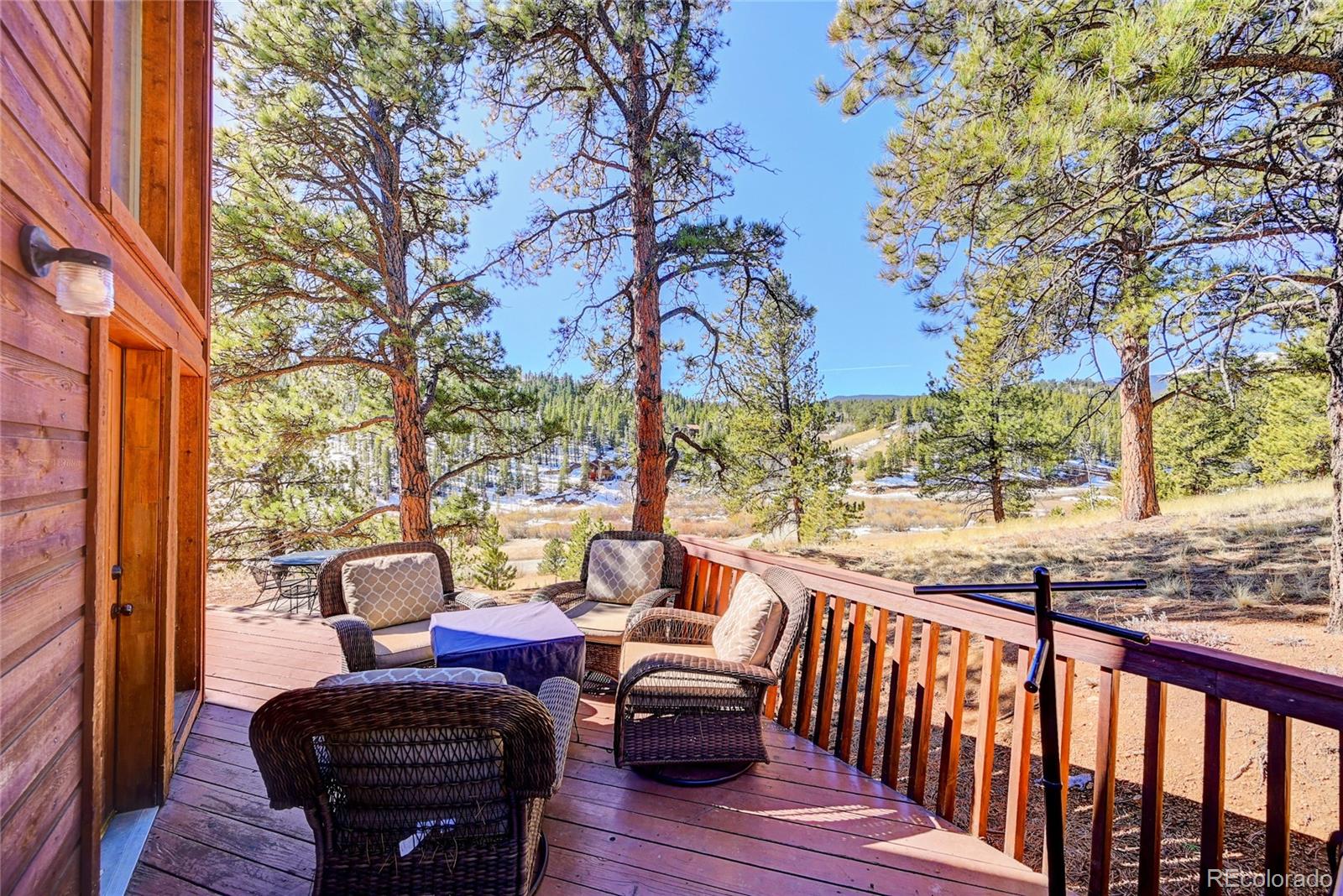 311 North Random Road Bailey, CO 80421 - Photo 8 of 40 a view of a patio with a table chairs and a fire pit