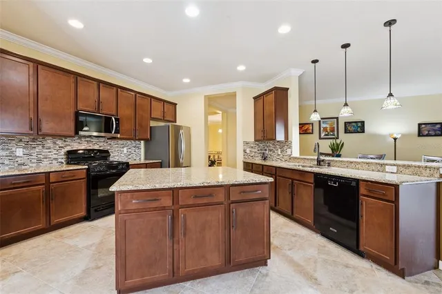 a kitchen with kitchen island a refrigerator and a stove top oven
