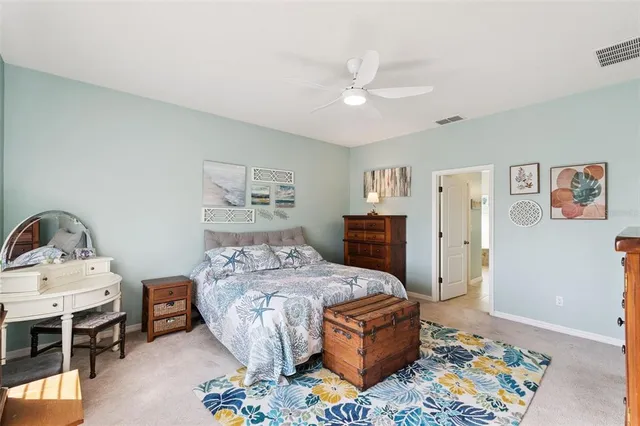 a bedroom with a bed table and two window