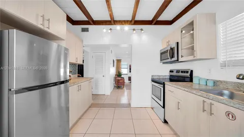 a kitchen with a refrigerator a sink and cabinets