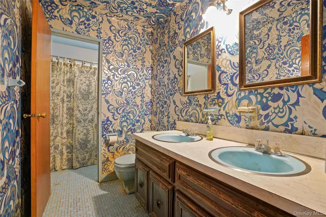 a bathroom with a sink a toilet and a mirror