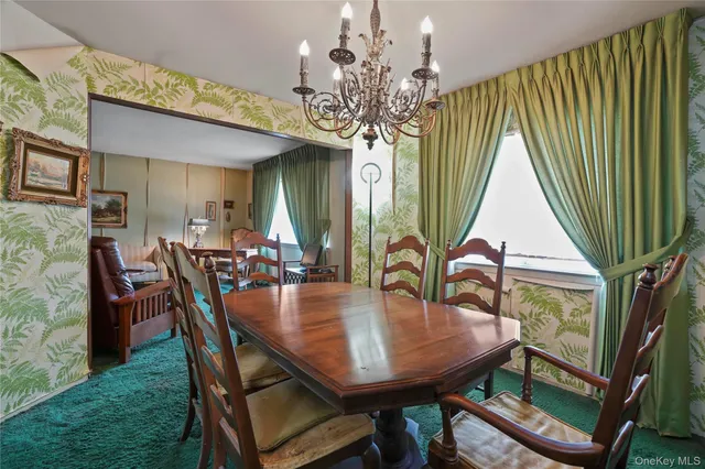 a dining room with furniture a chandelier and window