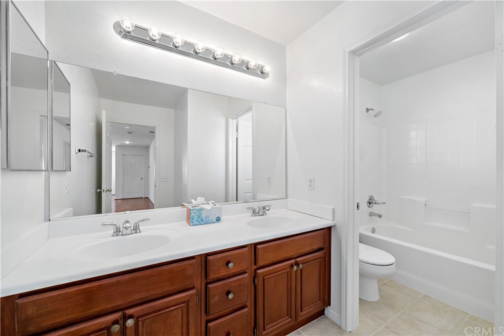 33782 Channel Street Temecula, CA 92592 - Photo 22 of 44 a bathroom with a granite countertop sink a toilet and a tub