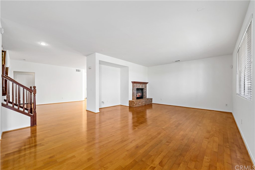 33782 Channel Street Temecula, CA 92592 - Photo 6 of 44 a view of empty room with wooden floor and fireplace