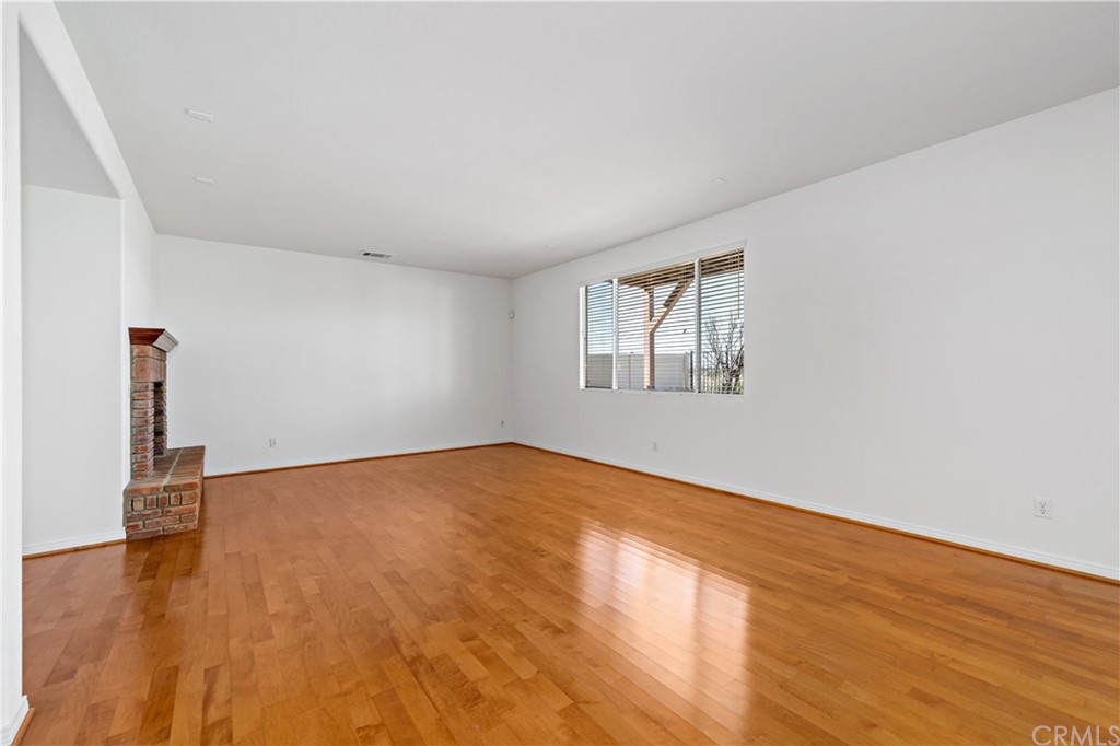 33782 Channel Street Temecula, CA 92592 - Photo 7 of 44 an empty room with wooden floor and windows