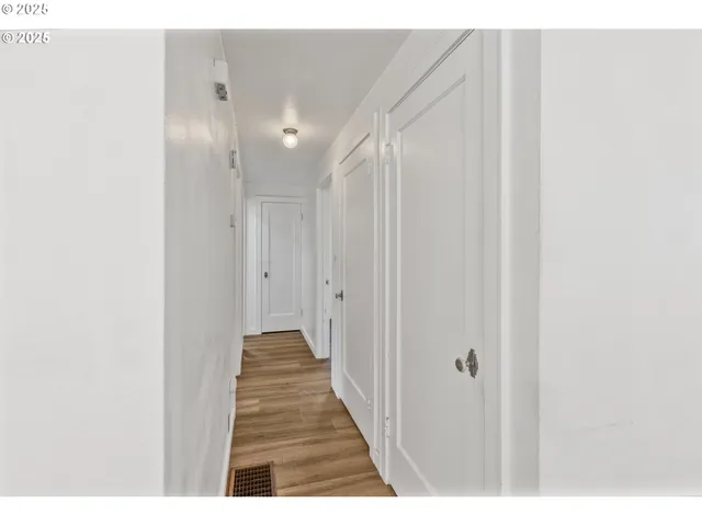 a view of a hallway with wooden floor