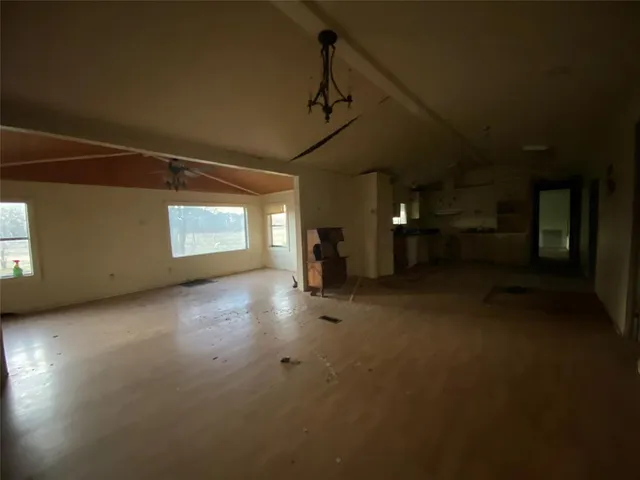 a view of a room with wooden floor and a ceiling fan