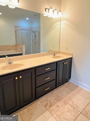 a bathroom with a granite countertop sink and a bathtub