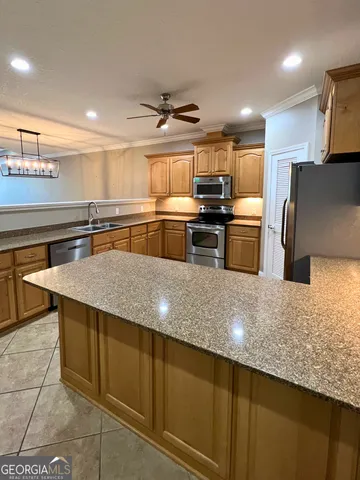 a kitchen with stainless steel appliances granite countertop a sink a stove top oven a counter space and cabinets