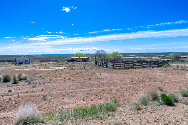 700 East Peter Springs Road Monticello, UT 84535 - Photo 43 of 57 Expansive rural property featuring a large wooden corral, a single-story residence, and an additional outbuilding, all set against a broad landscape