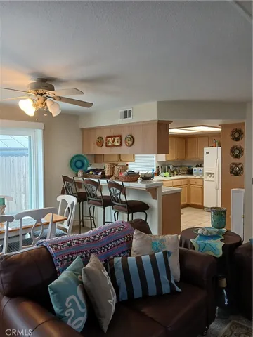 a living room with furniture kitchen view and a chandelier