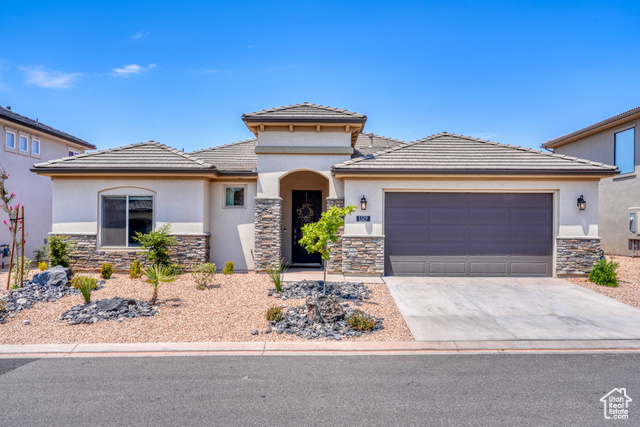1329 Paseos Street Washington, UT 84780 - Photo 3 of 35 Prairie-style home featuring stone siding, stucco siding, driveway, and an attached garage