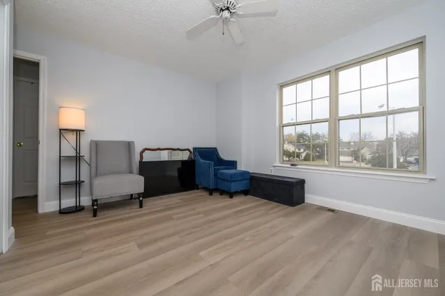 a view of a livingroom with a ceiling fan and wooden floor