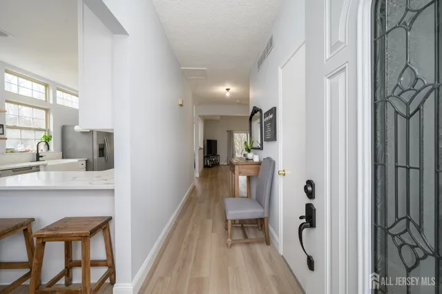 a view of a hallway with dining room and furniture