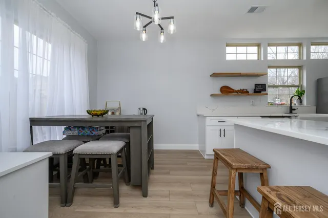 a kitchen with a dining table chairs and window