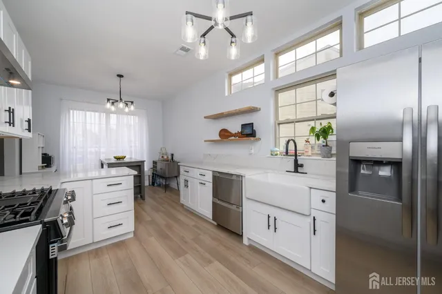 a kitchen with stainless steel appliances white cabinets and wooden floors
