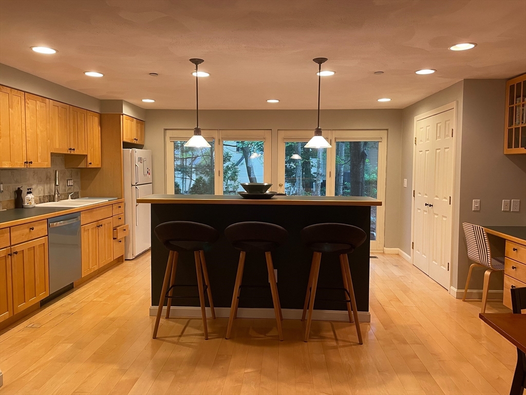 12 Deer Path, Unit 12 Hudson, MA 01749 - Photo 2 of 9 a kitchen with kitchen island a dining table chairs stainless steel appliances and cabinets