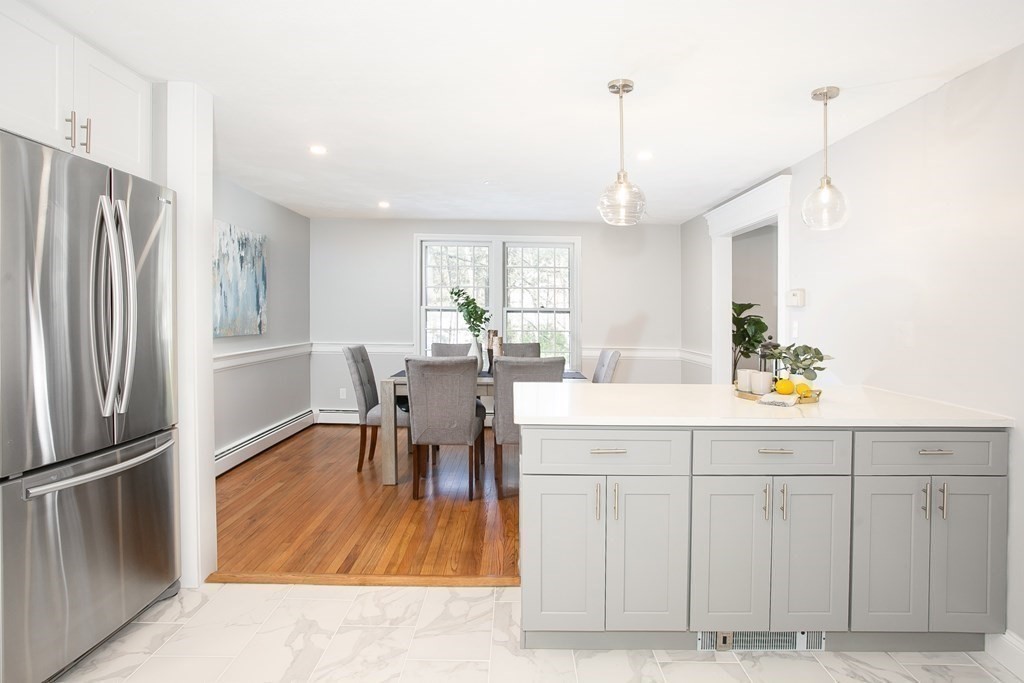 9 Countryside Way Andover, MA 01810 - Photo 5 of 36 a kitchen with stainless steel appliances granite countertop a refrigerator a sink dishwasher a dining table and chairs with wooden floor