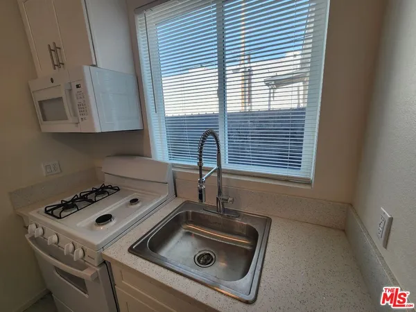a kitchen with a stove a sink and a window