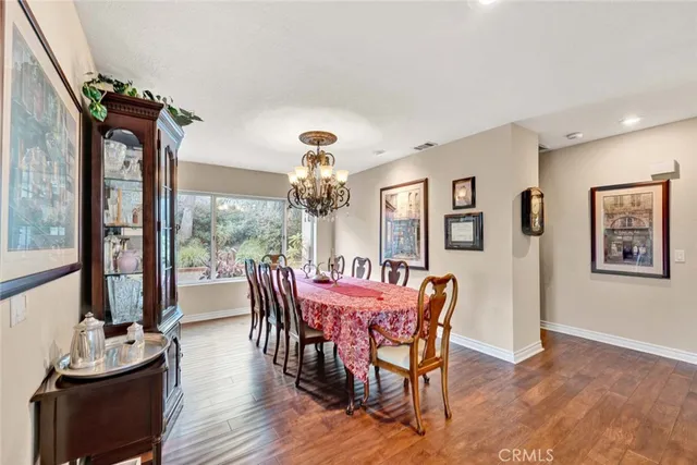 a view of a dining room with furniture a chandelier and wooden floor