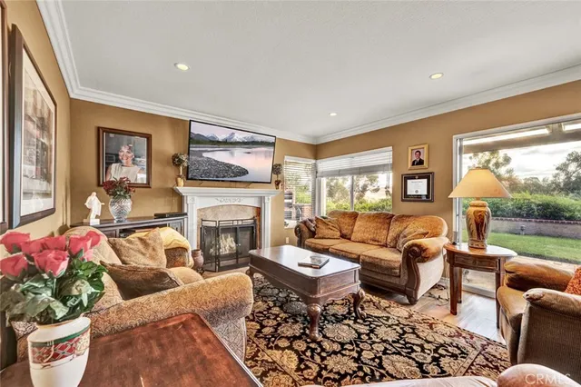 a living room with furniture fireplace and a large window
