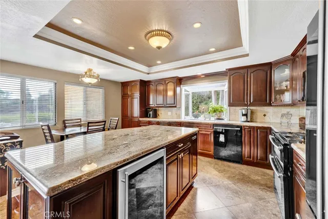 a kitchen with stainless steel appliances granite countertop wooden cabinets a stove top oven a sink and dishwasher