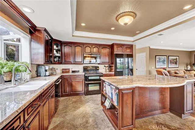 a kitchen with stainless steel appliances granite countertop a stove top oven a sink a counter space and cabinets