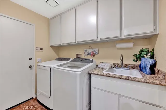 a kitchen with granite countertop a sink a stove and cabinets
