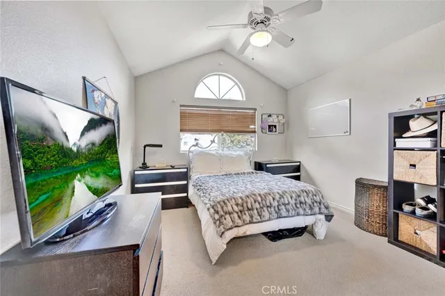 a bedroom with a bed window and flat screen tv