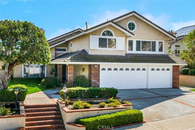 a front view of a house with a yard and potted plants