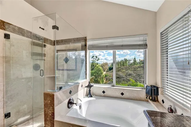 a large white bed sitting in a bathroom next to a window