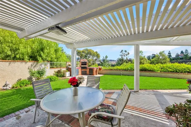 a patio with table and chairs and potted plants